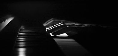 hands on piano keys in the dark