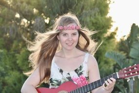 Young girl playing on a guitar