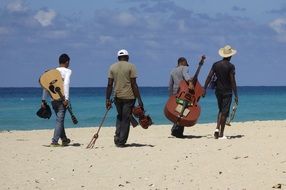 Musicians walk along the beach