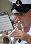 trumpeter in navy cap playing outside