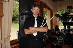 drummer, mature man with drumsticks in front of instruments