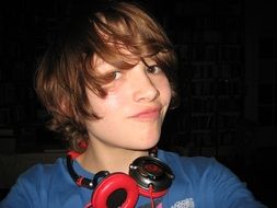 teenager with headphones on black background