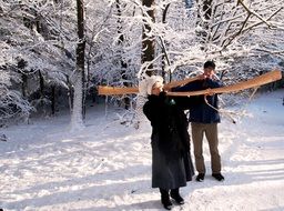 men carry a musical horn in the winter forest