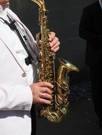 musician in white costume plays the saxophone