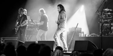 black and white photo of a rock band on stage
