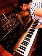 girl tunes an antique piano