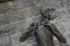 statue of a boy playing on flute