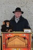 man and a toy monkey at the organ