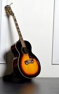 yellow-black guitar against the wall
