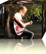 Romantic long-haired musician playing the guitar in the park