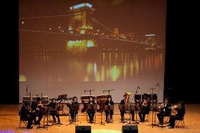 concert on the stage on the background of the urban bridge