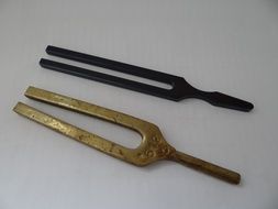 metal tuning fork on a white surface
