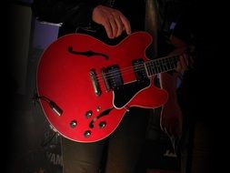 red bass guitar in man's hands