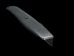 carpet knife on the black background