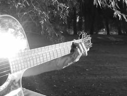 Man's fingers plucking guitar strings