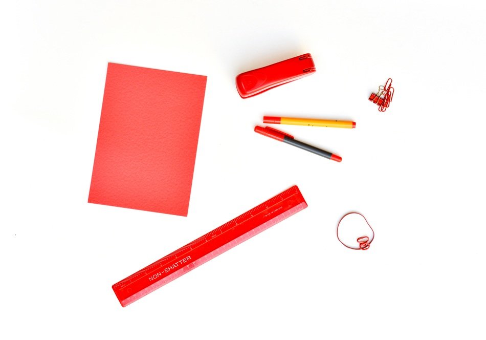 Different red supplies on the white desk