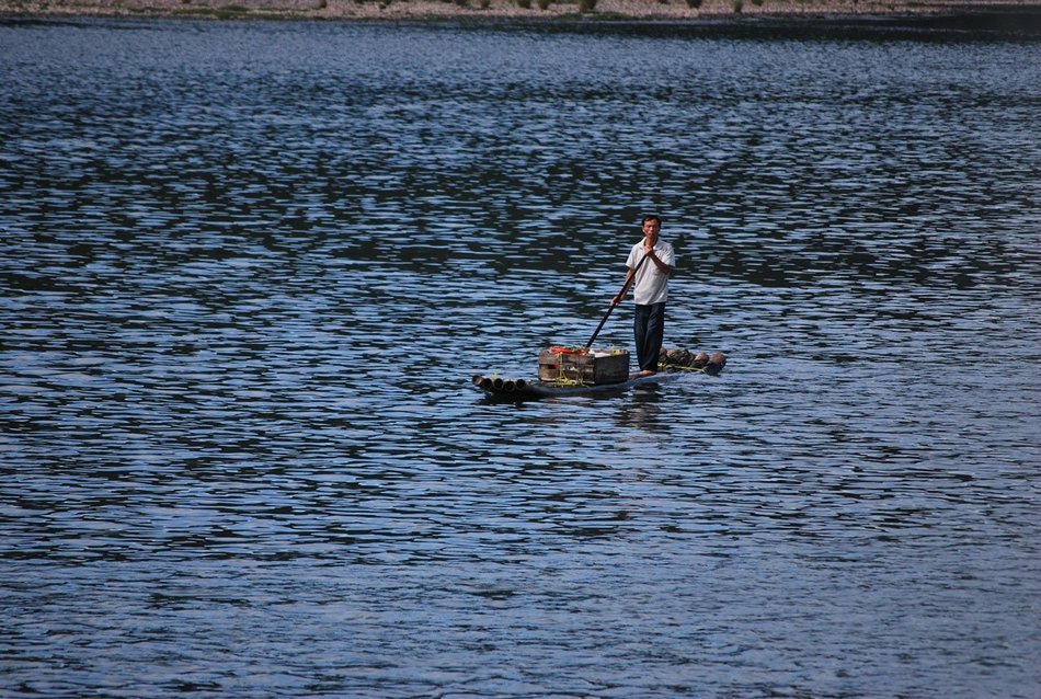 asian man on boat loaded with fruits