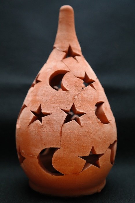 Ceramic lamp with holes in the form of stars