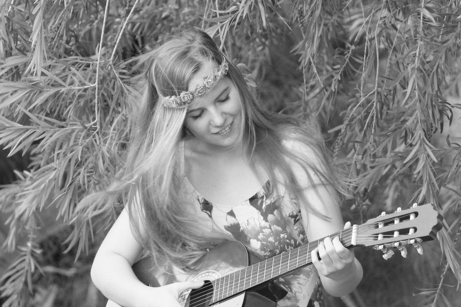 black and white image of a girl who plays the guitar