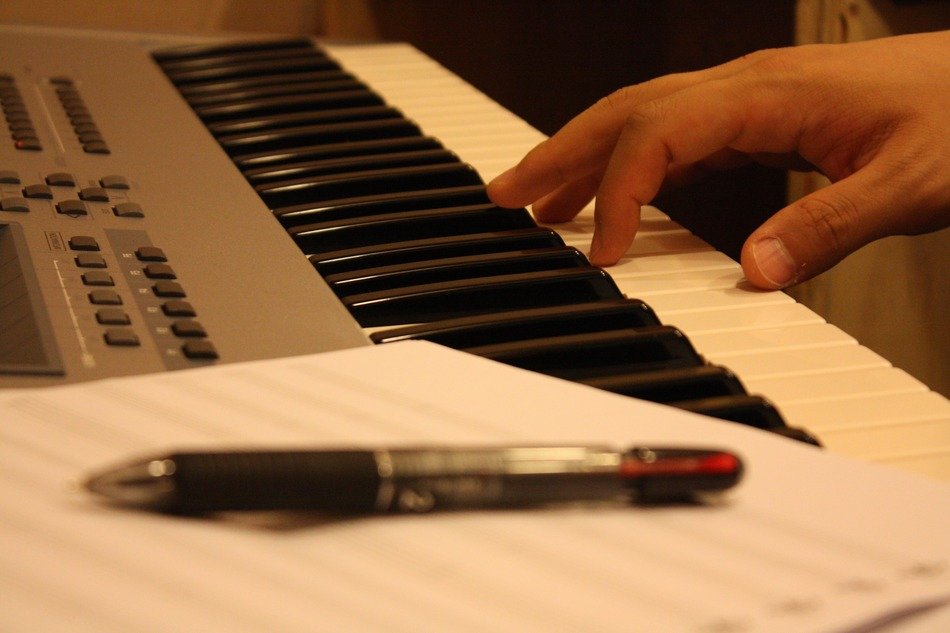 hand on the piano and pen