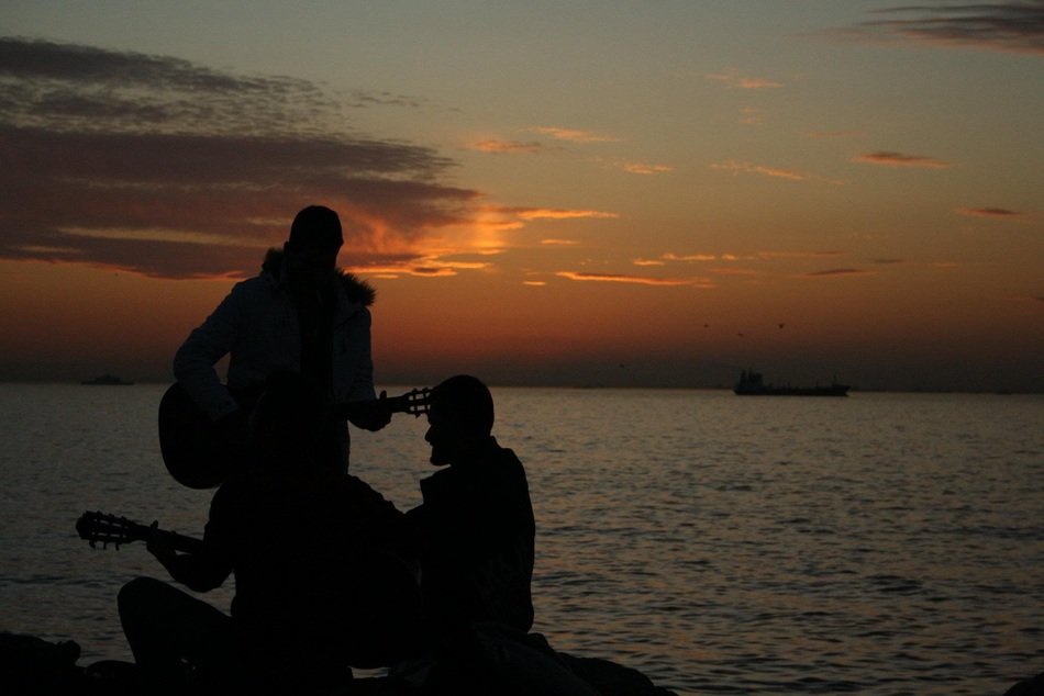silhouettes of a guitarist on the beach