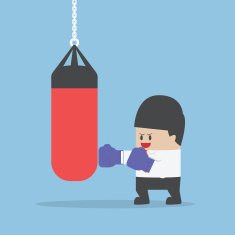 Businessman wearing boxing gloves and punch the punching bag