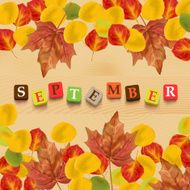 Autumn background with leaves and colorful letters &quot;september&quot;