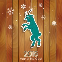 Green goat decoration on a wooden background