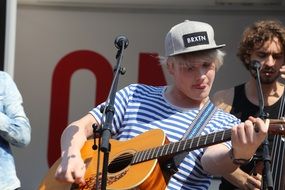 young musician playing acoustic guitar