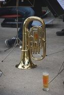 brass musical instrument and a glass of beer in the street