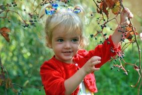 little girl blonde in the green garden