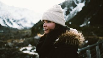 girl in a white hat on a background of mountains