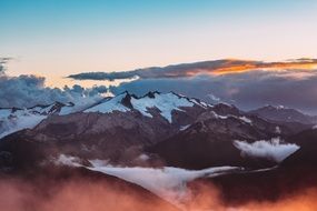 scenic snow capped mountain summit at clouds