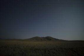 Green hills under a beautiful, dark, gradient night sky