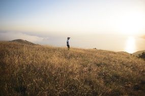 Man in field near the ocean