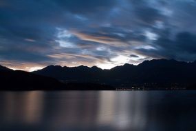 sunset on the lake on a background of mountains and clouds