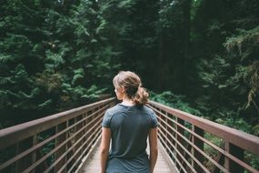 girl standing on a footbridge