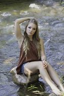 young girl sitting by the creek