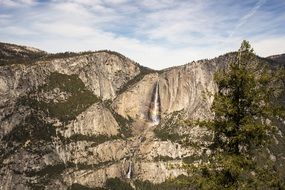 high waterfall falling from the rocks with colorful nature