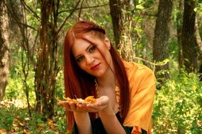 girl in a yellow dress with autumn leaves in the hands