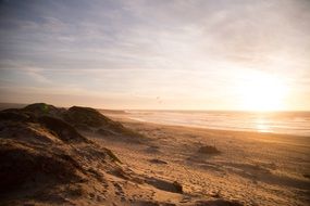 evening sun over the beach by the ocean