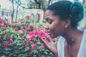 Girl sniffs pink flowers