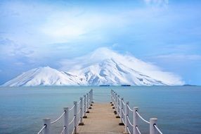 wooden pier on the background of snowy mountains