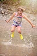 Little girl in yellow boots in jump