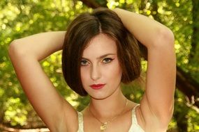 portrait of a girl with long hair in a white dress on the forest background