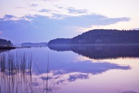 Landscape of the beautiful lake and the forest at colorful sunset in Finland