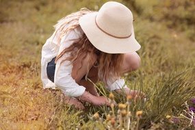 Blonde Girl in white hat takes flowers
