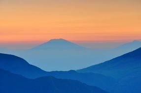 gorgeous landscape with blue mountains and orange sky