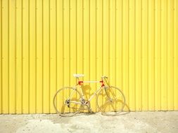 sports bicycle parked at yellow wall