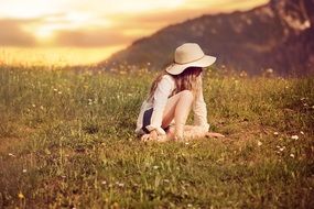 Little girl in a wide-brimmed hat in the meadow